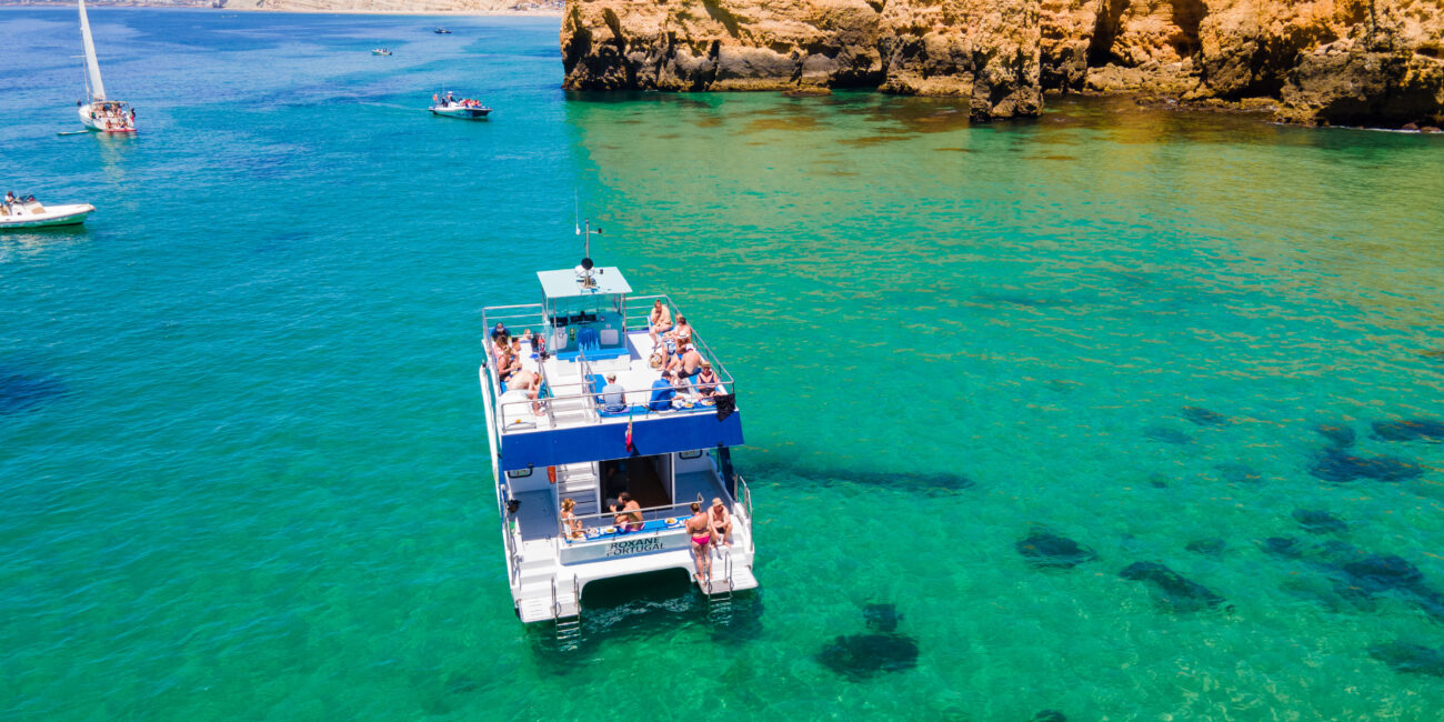 Catamaran cruising along the golden cliffs of Lagos