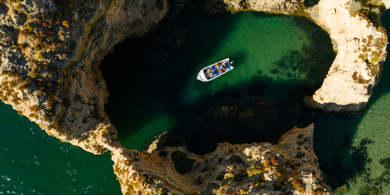Small boat entering a sea grotto at Ponta da Piedade, Lagos