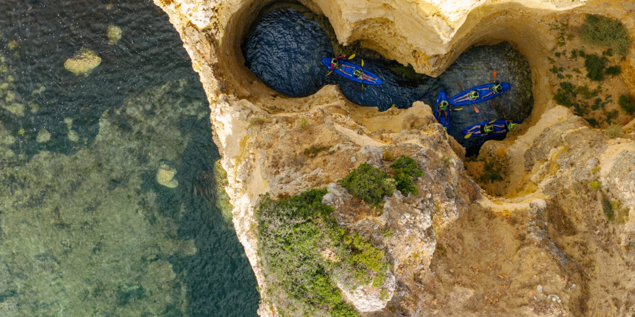 Kayaks passing a rock arch near Lagos